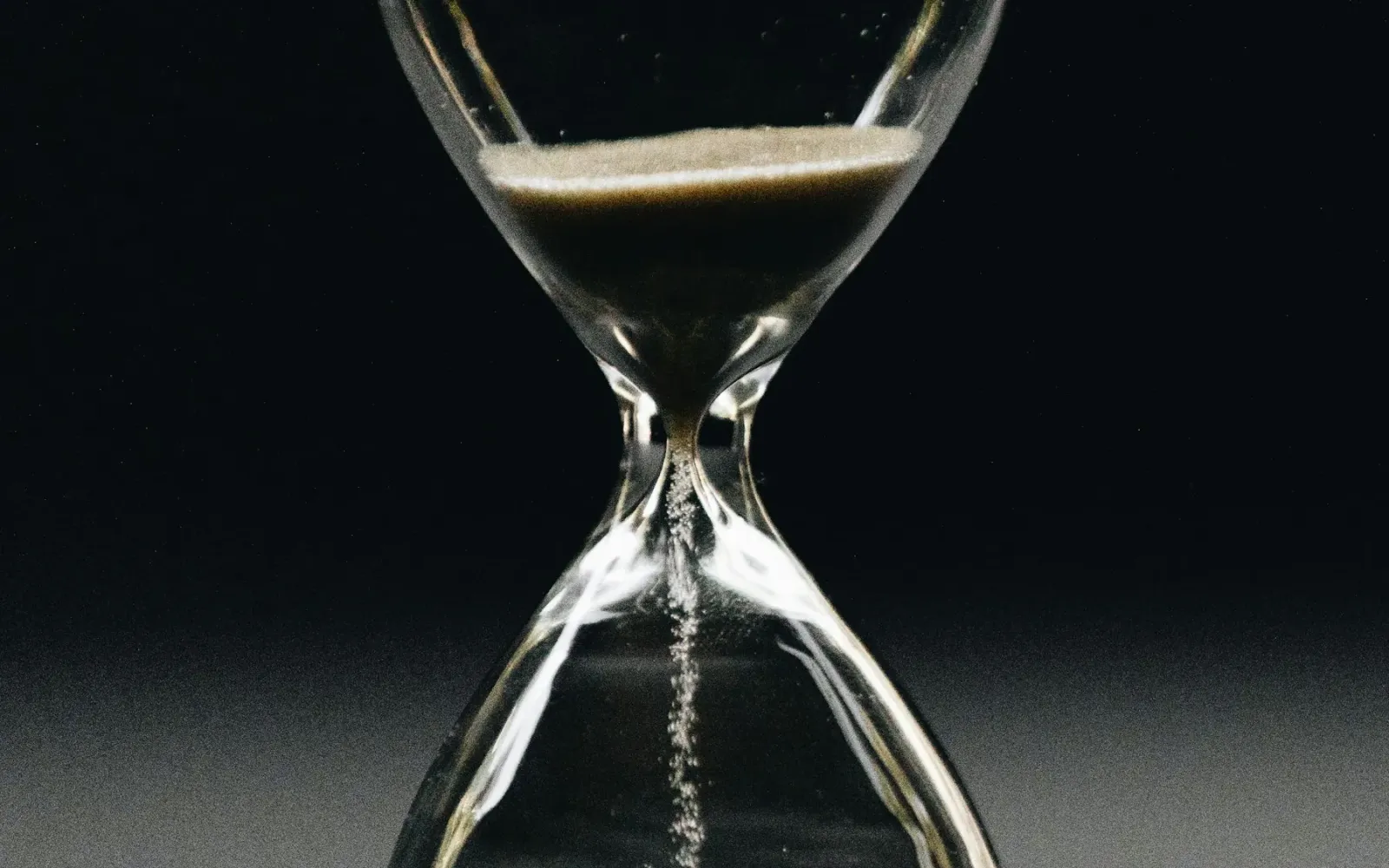 A clear hourglass with sand running through it