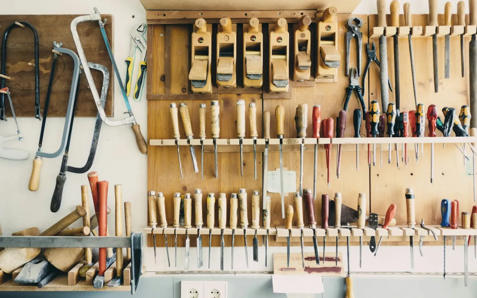 Hand tools neatly arranged on a workshop wall rack